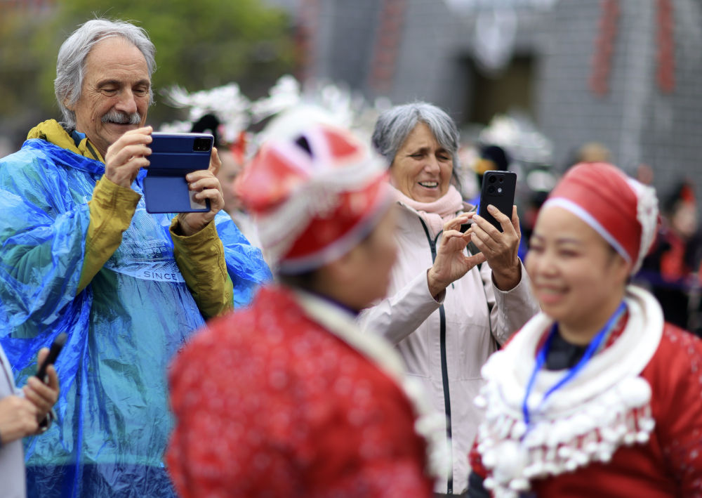 4月12日，外國游客在貴州省黔東南苗族侗族自治州臺江縣舉行的“苗族姊妹節(jié)”慶?；顒由吓臄z。新華社記者劉續(xù) 攝.jpeg